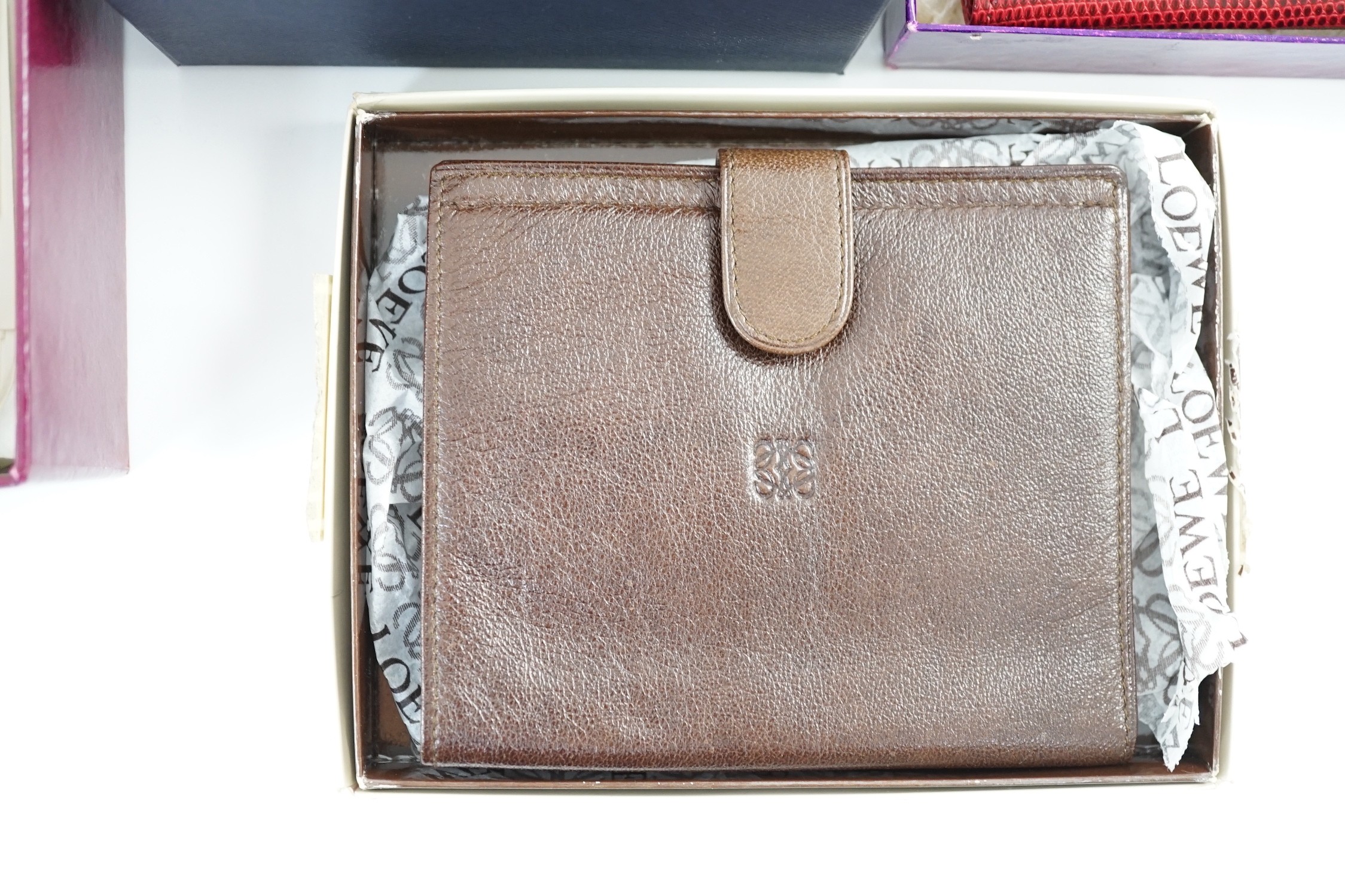 A set of two Asprey leather address books (initialled), an Asprey snakeskin wallet, a Loewe brown leather wallet and an Aspinal heart key fob